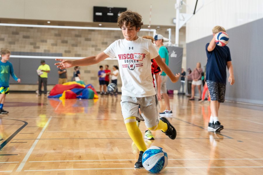 A camper playing soccer indoors.